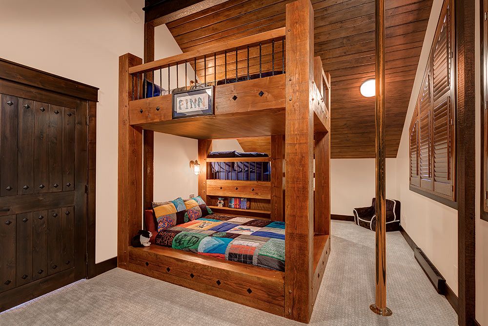 Custom bunk beds with rough cut timbers and fireman's pole.